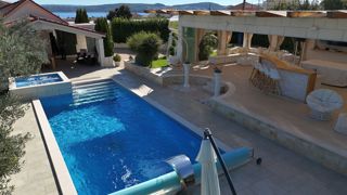 Una bella casa in pietra con un grande giardino e piscina