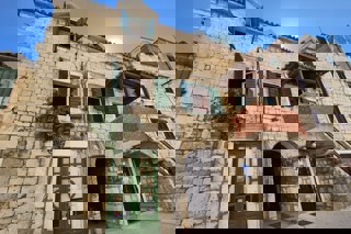 Casa tradizionale in pietra con spazio commerciale, vicino al lungomare