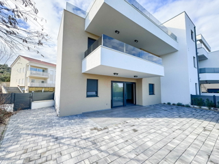 Appartamento al piano terra di un edificio con due camere da letto e due posti auto.