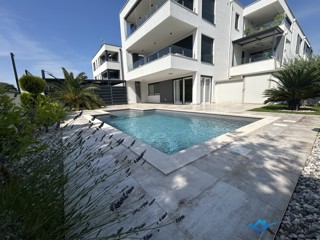 Appartamento top, piscina riscaldata, giardino da sogno di facile manutenzione, posto auto coperto con serratura per 4 auto