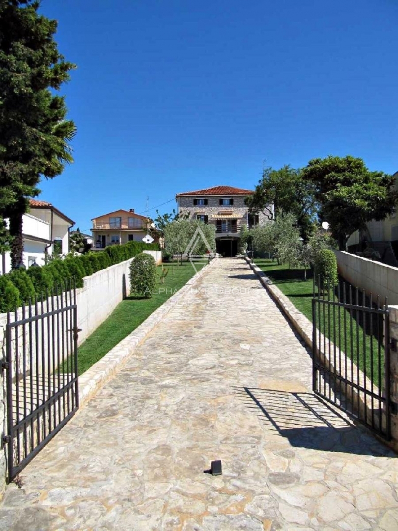 Casa in pietra d'Istria con un bellissimo giardino, situata in prima fila sul mare, Umago, ISTRIA.