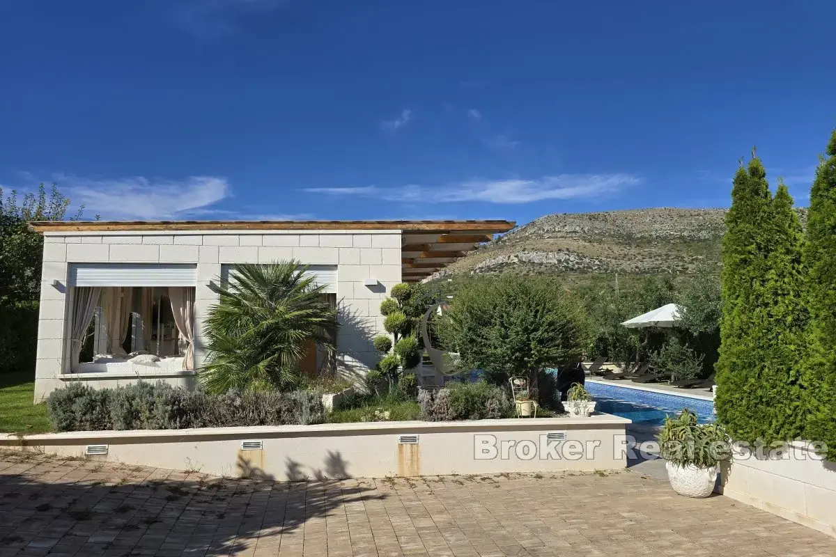 Una bella casa in pietra con un grande giardino e piscina