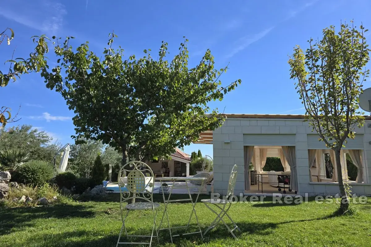 Una bella casa in pietra con un grande giardino e piscina