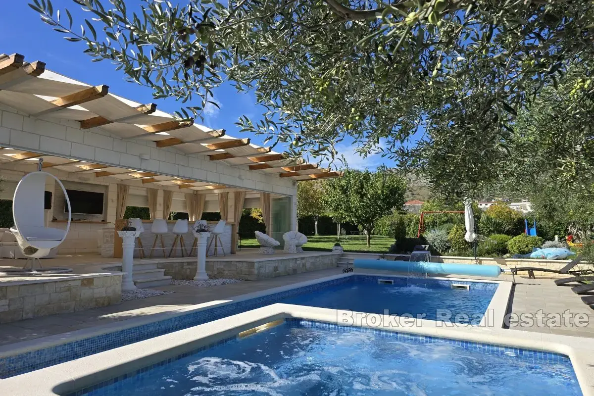 Una bella casa in pietra con un grande giardino e piscina