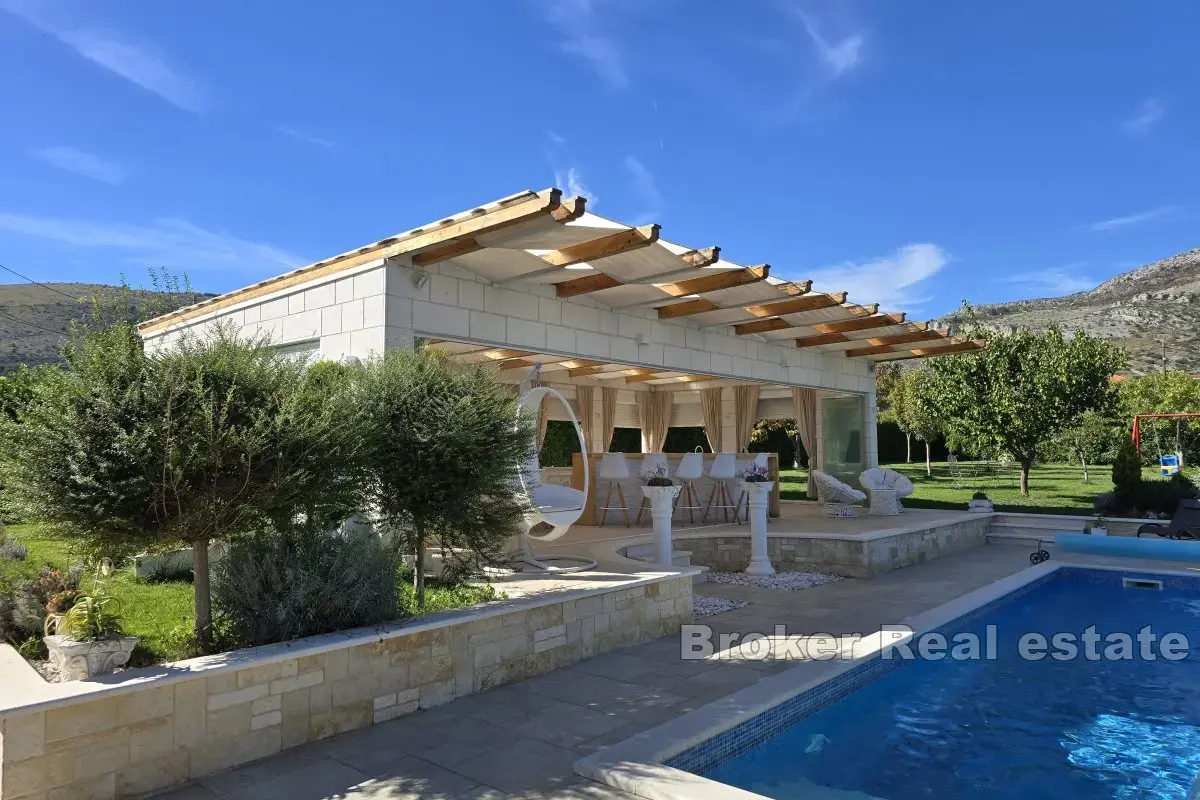 Una bella casa in pietra con un grande giardino e piscina