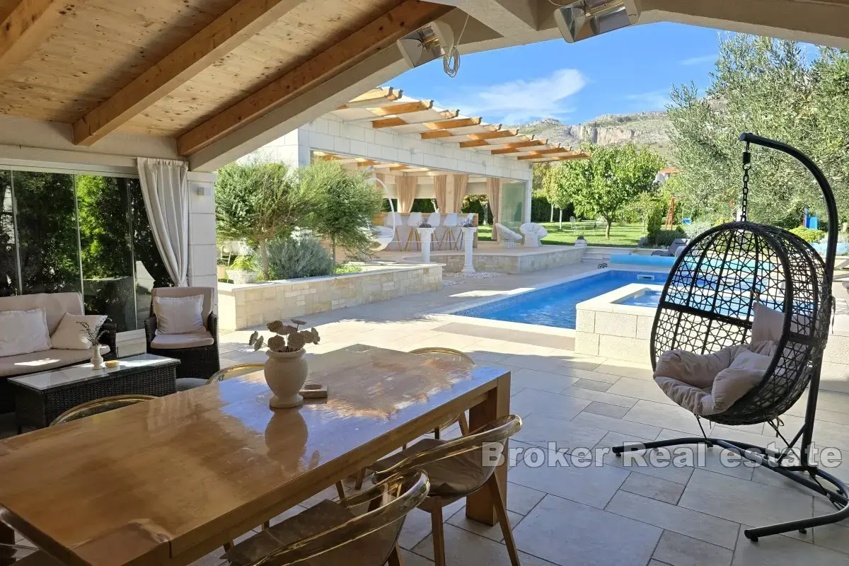 Una bella casa in pietra con un grande giardino e piscina