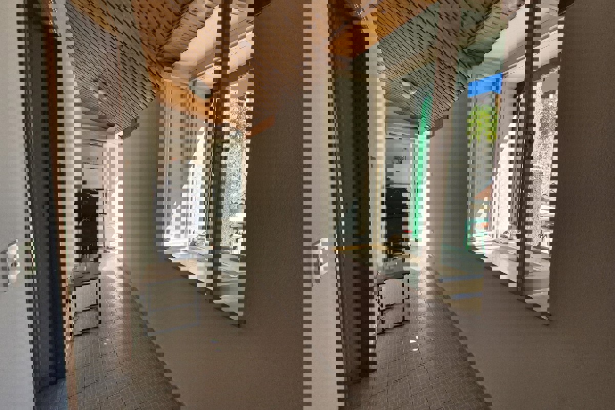 Casa tradizionale in pietra con spazio commerciale, vicino al lungomare