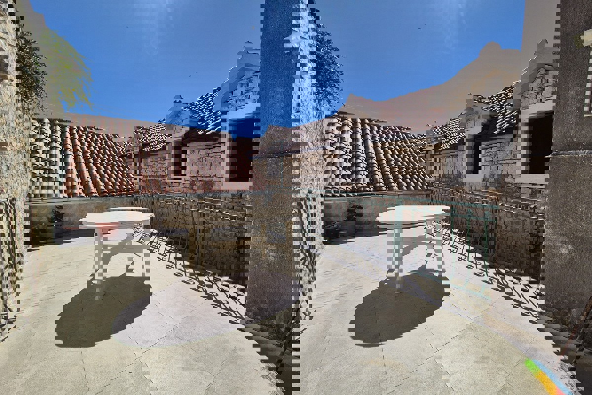 Casa tradizionale in pietra con spazio commerciale, vicino al lungomare