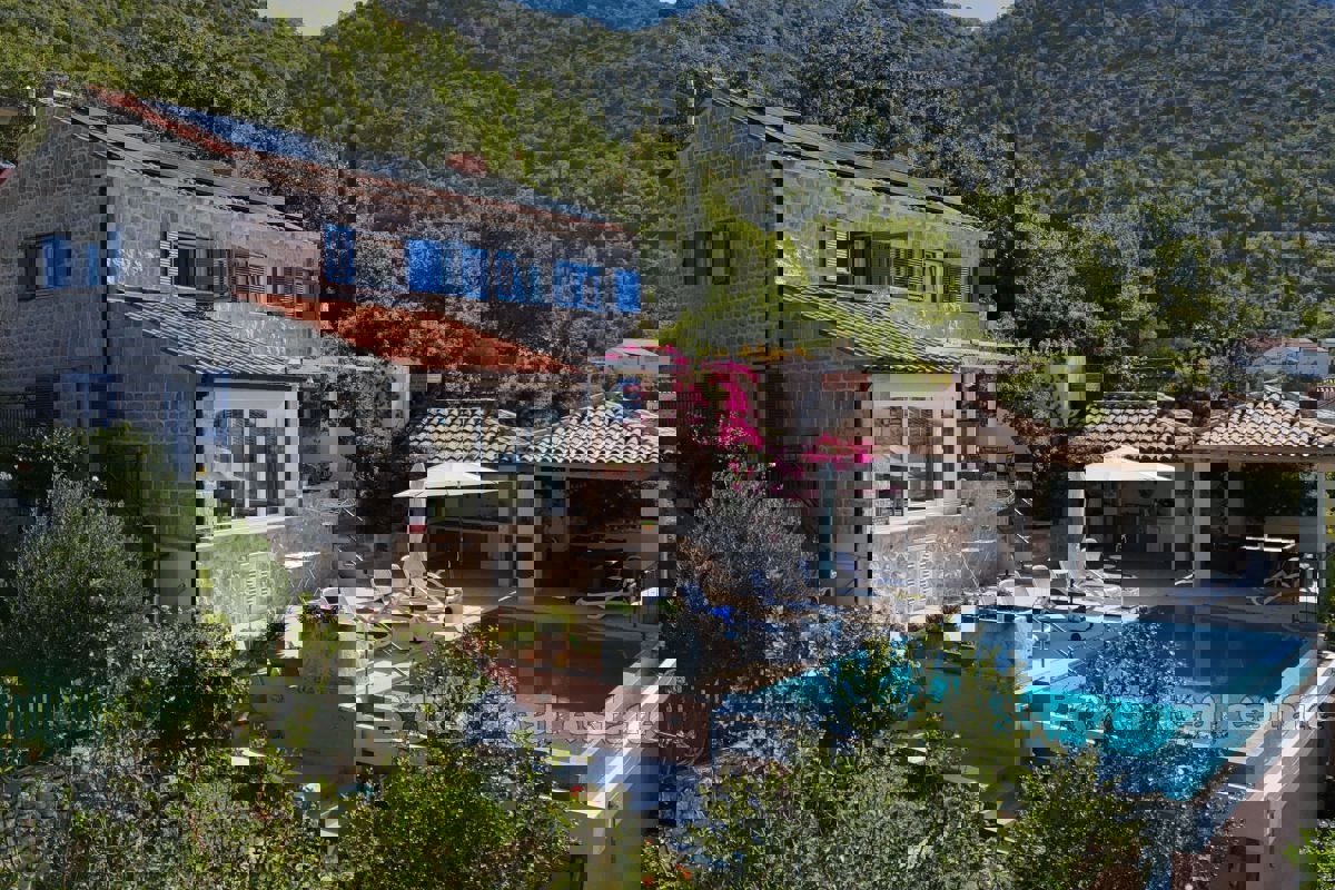 Una villa in pietra con piscina e una vista incantevole sul mare