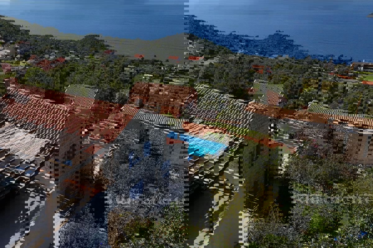 Una villa in pietra con piscina e una vista incantevole sul mare
