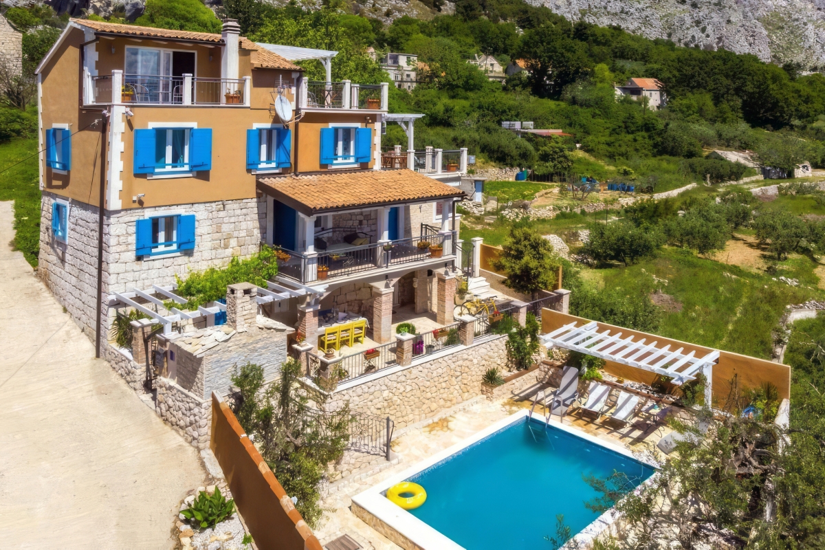 Casa in pietra con piscina e vista mare aperta
