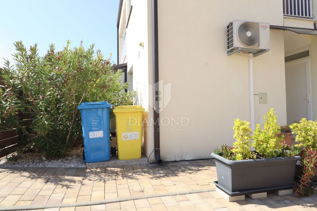 Nuova costruzione! Appartamento trilocale al piano terra con ampio giardino e parcheggio. A 1 km dal mare, nel centro del paese.