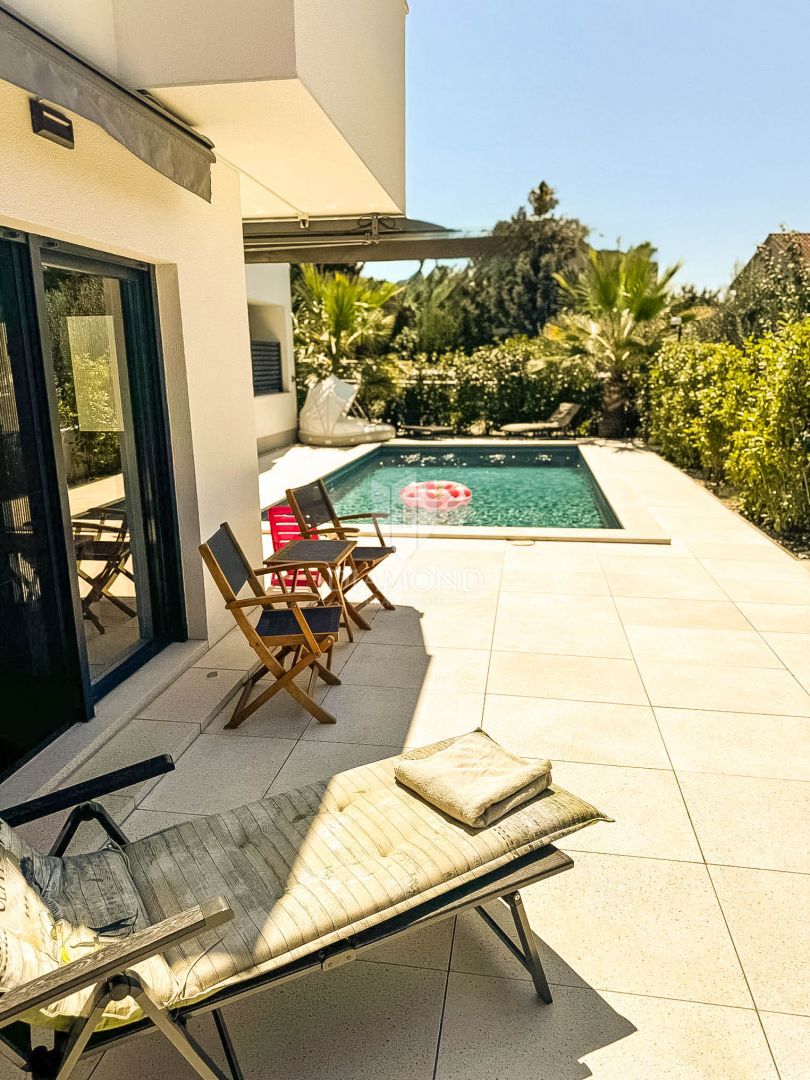 Appartamento al piano terra con piscina privata e giardino.