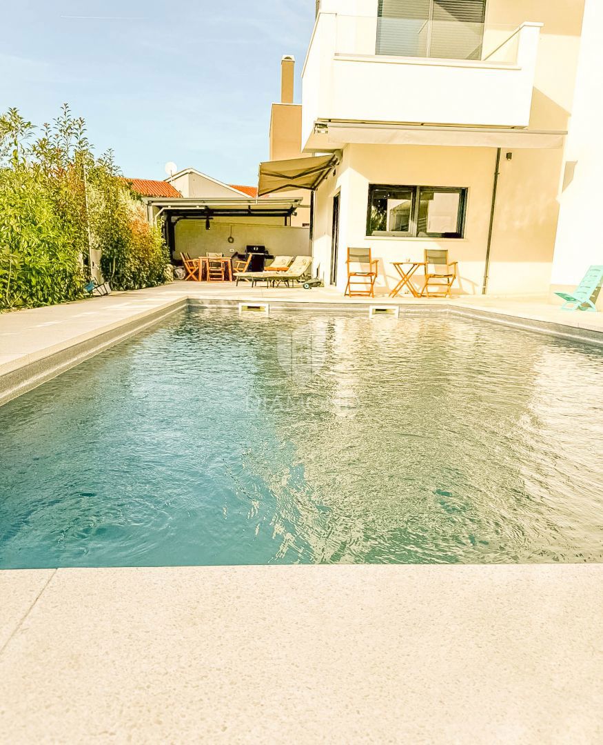 Appartamento al piano terra con piscina privata e giardino.