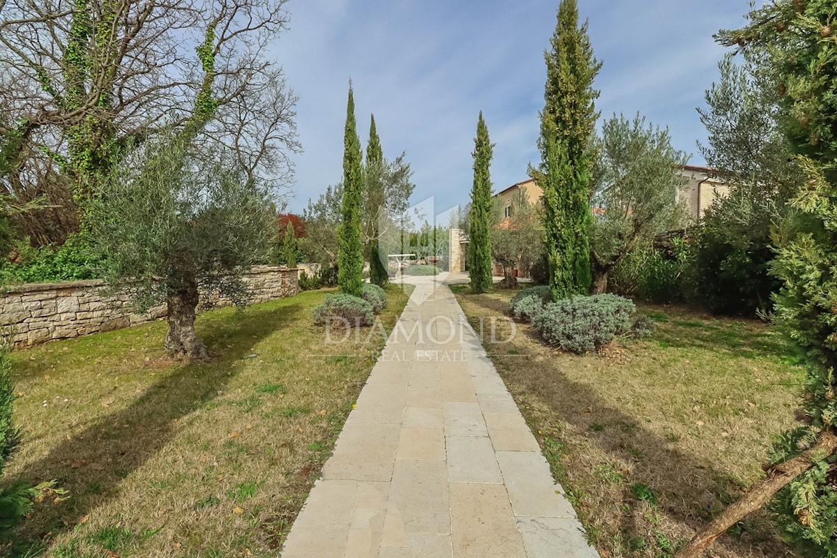 Un'imponente villa in pietra su un ampio giardino