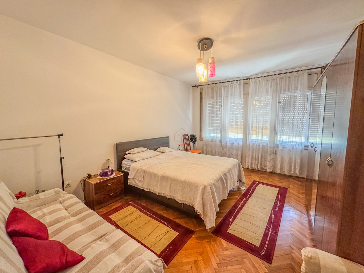 Appartamento con due camere al secondo piano di un edificio con due balconi, stanze spaziose e posto auto in garage