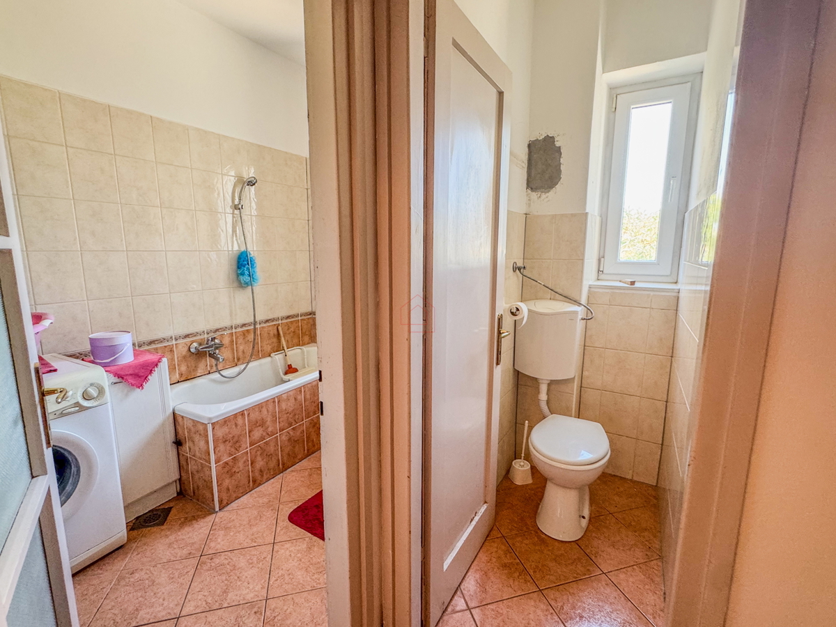 Appartamento con due camere al secondo piano di un edificio con due balconi, stanze spaziose e posto auto in garage