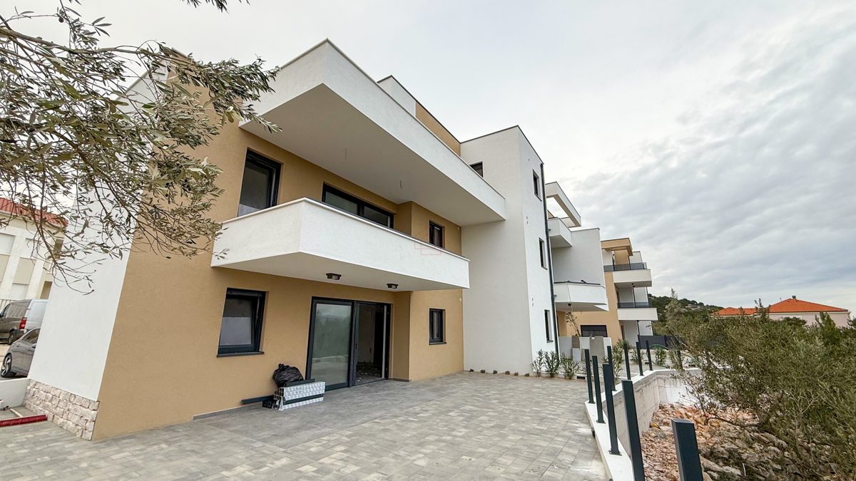 Appartamento al piano terra di un edificio con due camere da letto e due posti auto.