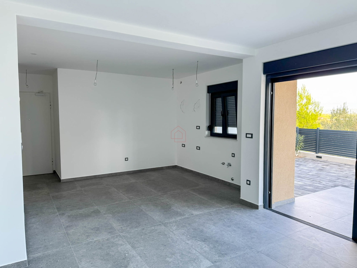 Appartamento al piano terra di un edificio con due camere da letto e due posti auto.