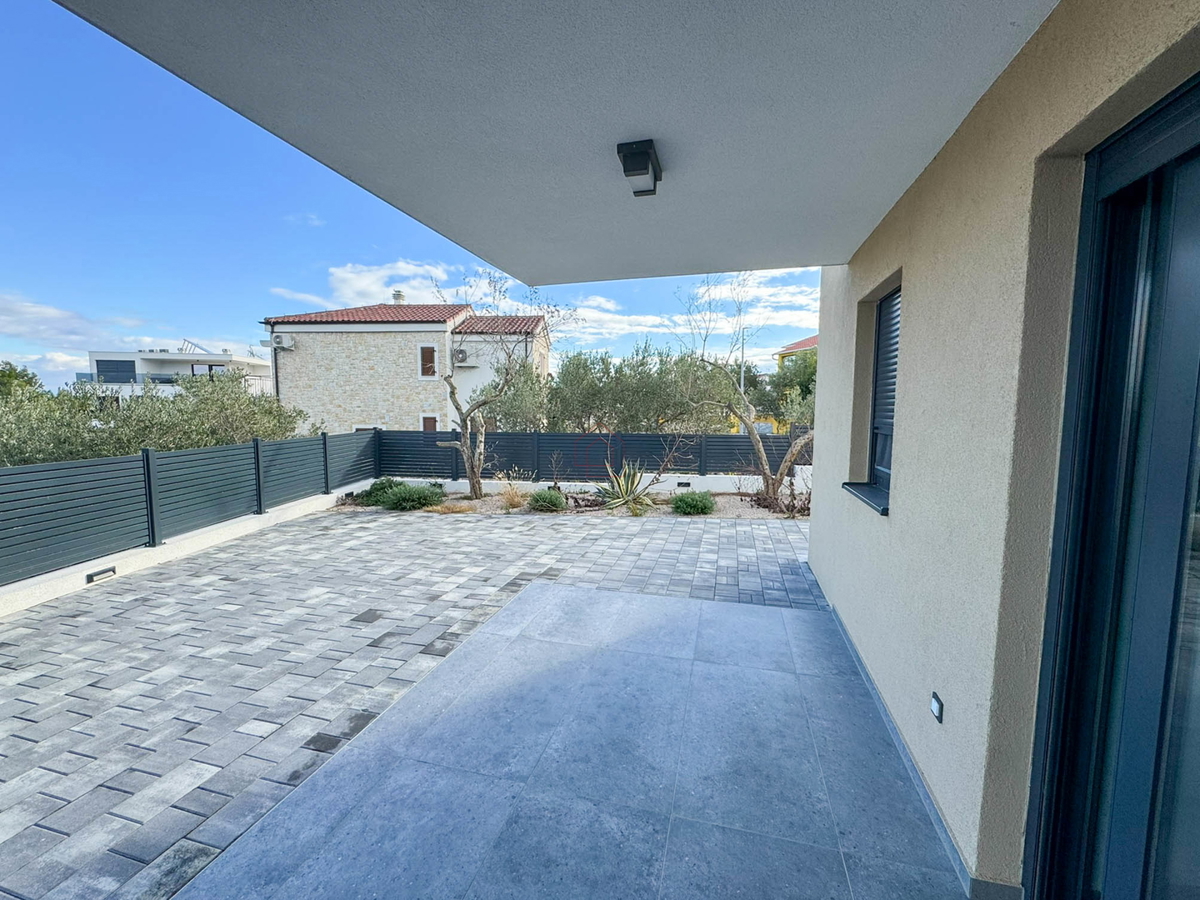 Appartamento al piano terra di un edificio con due camere da letto e due posti auto.