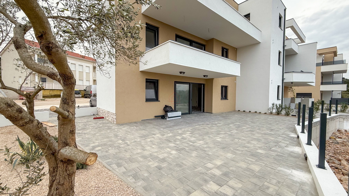 Appartamento al piano terra di un edificio con due camere da letto e due posti auto.