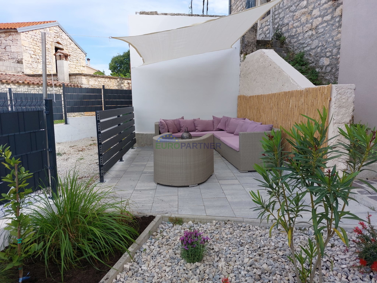 Casa in pietra a schiera con giardino.