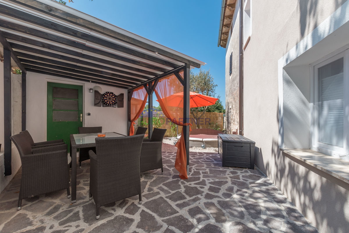 Casa in pietra a schiera con giardino.