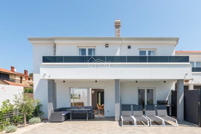 Una casa bifamiliare con piscina vicino alla spiaggia ai margini di un grazioso villaggio