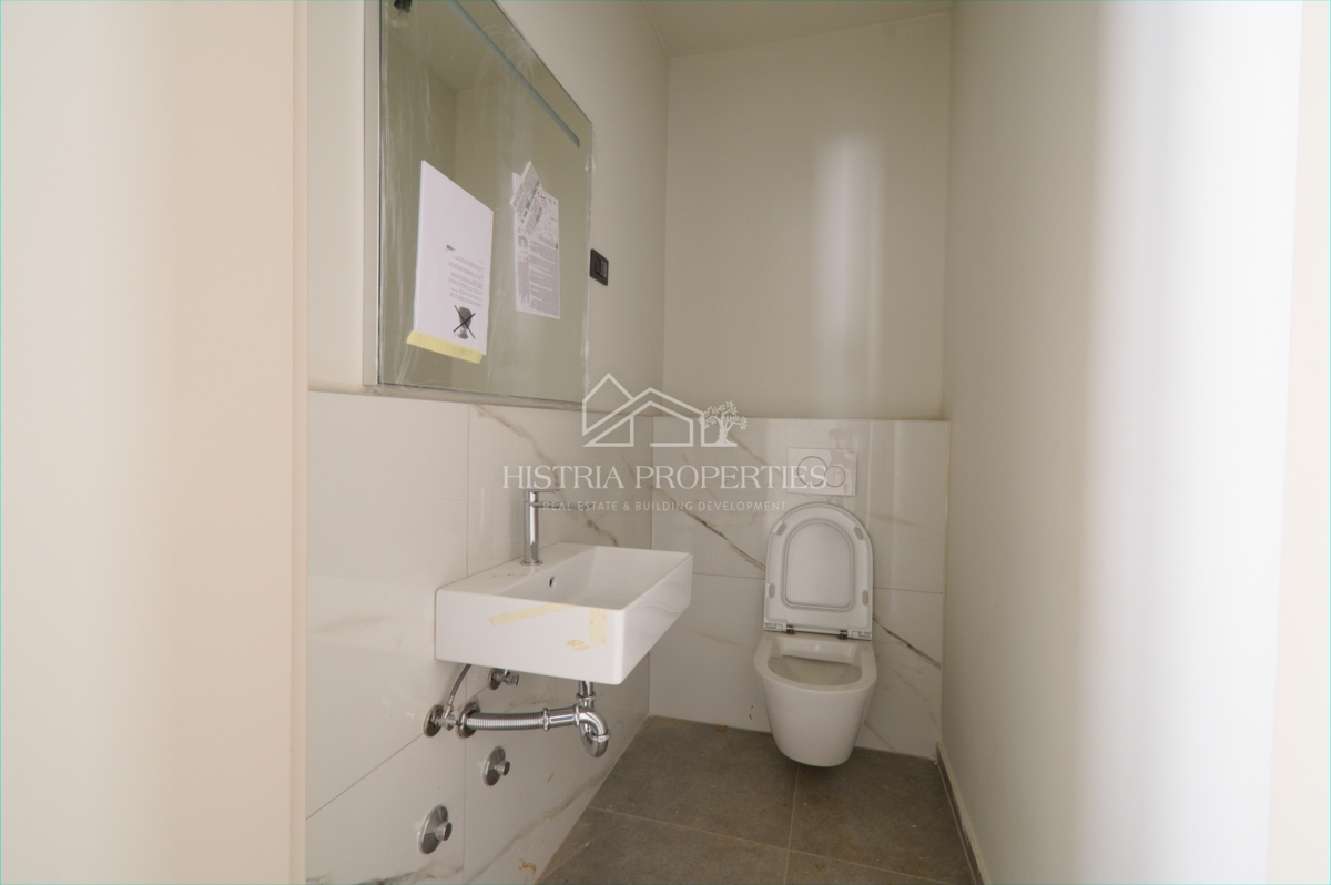 Un attraente insediamento con un nuovo appartamento con giardino vicino alla spiaggia