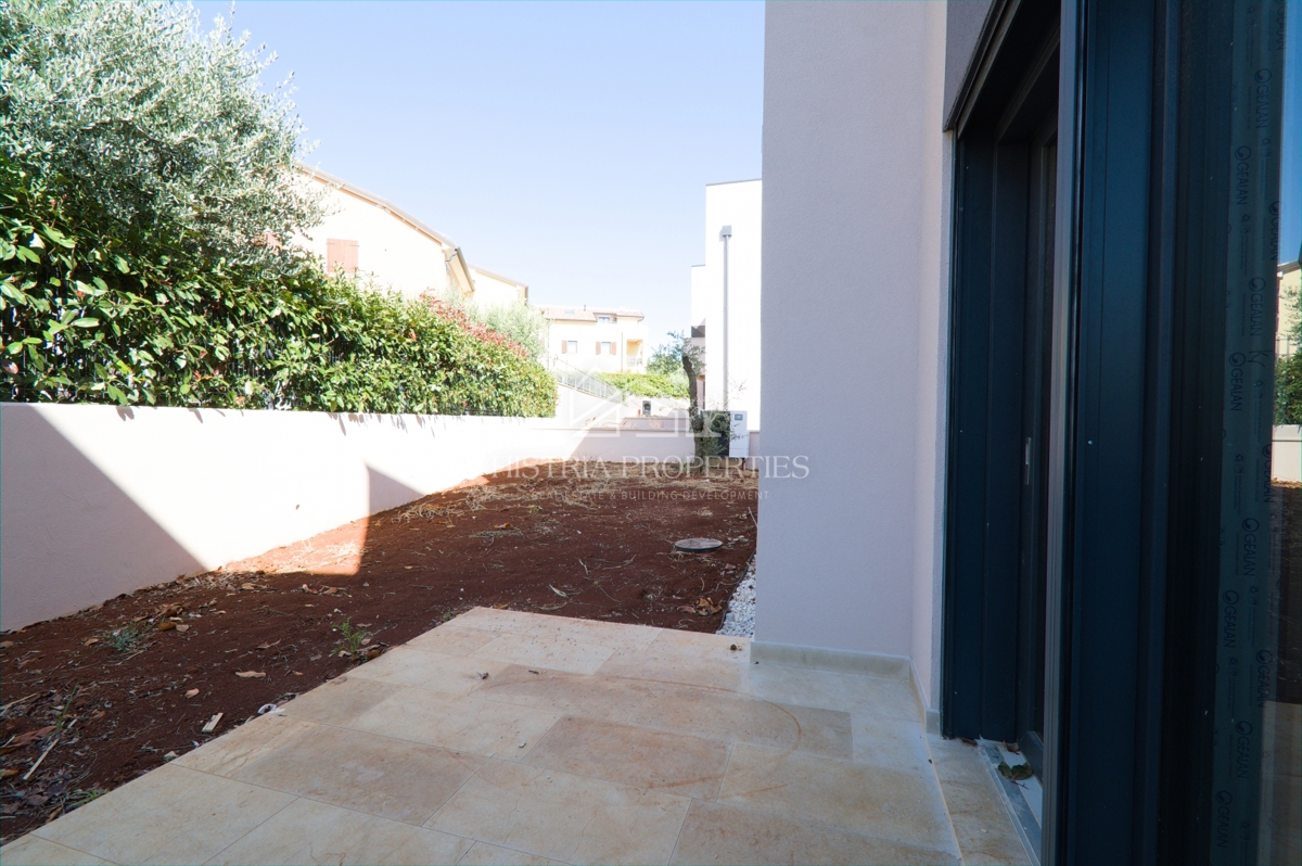 Un attraente insediamento con un nuovo appartamento con giardino vicino alla spiaggia