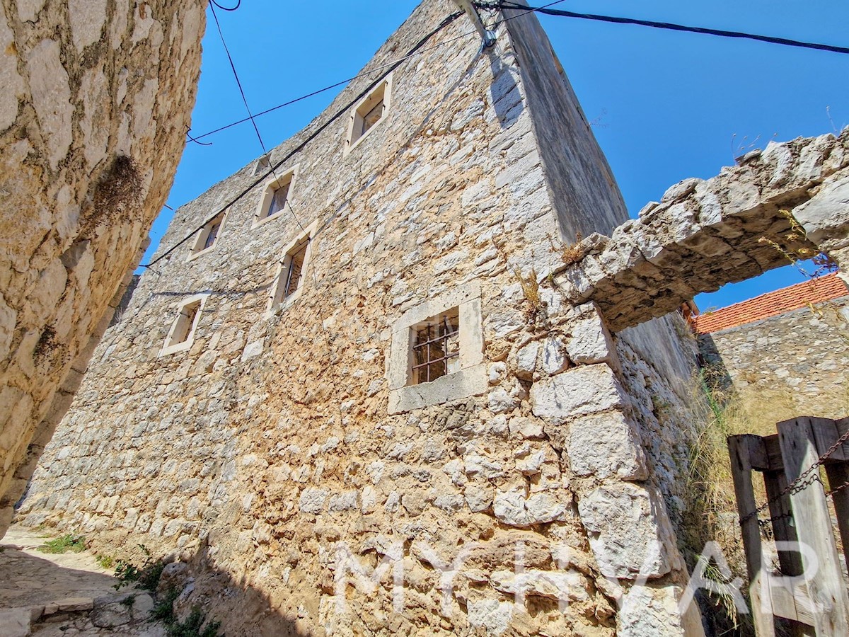 Casa in pietra con rudere adiacente