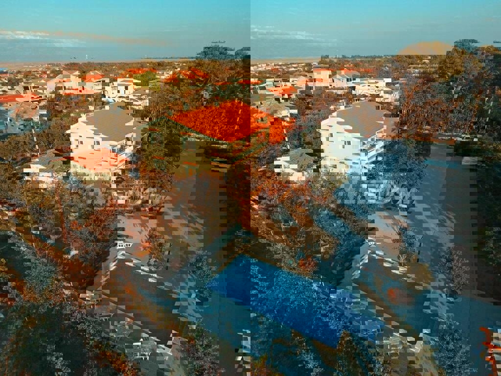 Edificio residenziale e commerciale con ampio giardino e piscina