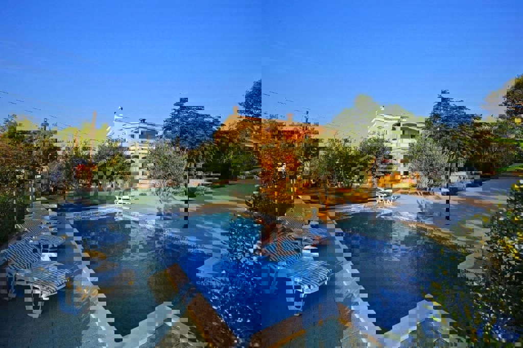 Edificio residenziale e commerciale con ampio giardino e piscina